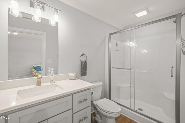 bathroom with toilet, a shower stall, wood finished floors, and vanity
