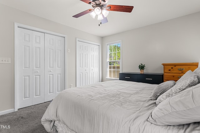 bedroom featuring baseboards, carpet flooring, multiple closets, and ceiling fan