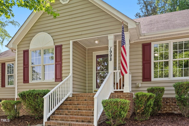 view of front of house with roof with shingles and a porch