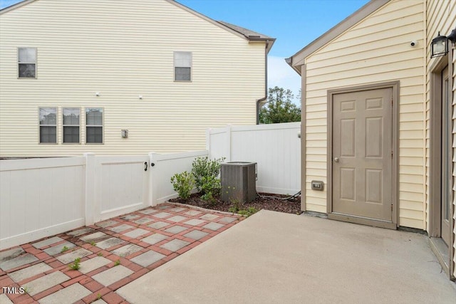 view of property exterior featuring a patio, central air condition unit, a fenced backyard, and a gate