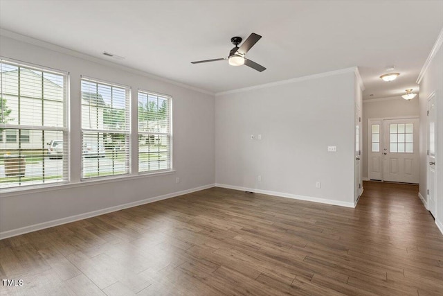 spare room with ornamental molding, wood finished floors, a ceiling fan, and baseboards