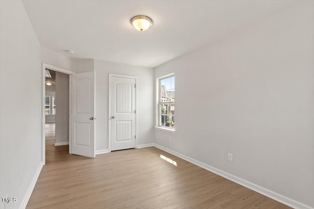 unfurnished bedroom with light wood-style flooring and baseboards