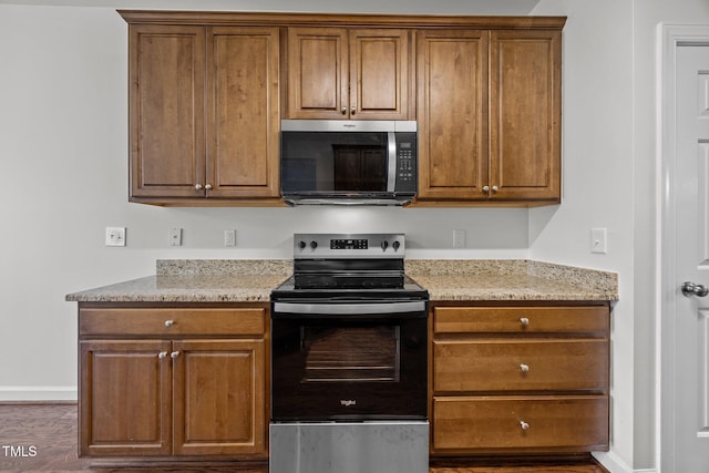 333 Trout Valley Rd, Wake Forest, NC 27587 - kitchen with appliances with stainless steel finishes, brown cabinets, wood finished floors, and light stone counters