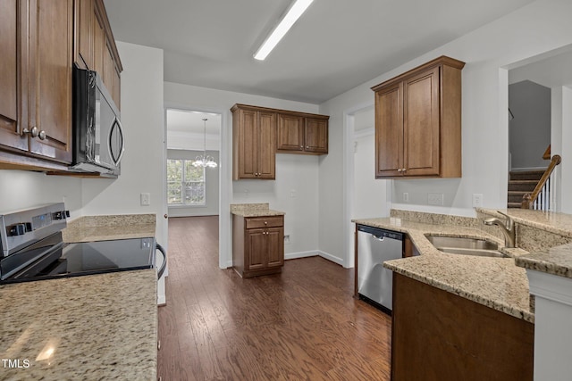 333 Trout Valley Rd, Wake Forest, NC 27587 - kitchen with appliances with stainless steel finishes, light stone countertops, dark wood-style floors, and brown cabinets
