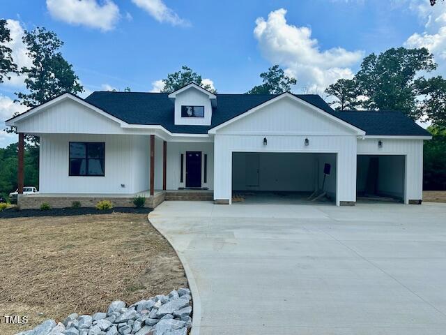 297 Dry Branch Dr, Kenly, NC 27542 - modern inspired farmhouse with driveway, covered porch, and a garage