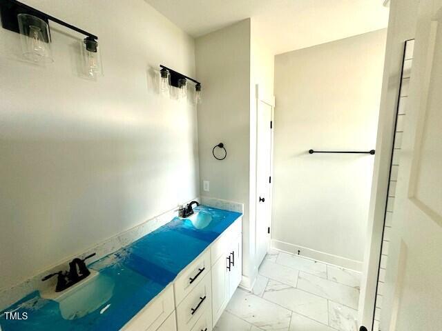 297 Dry Branch Dr, Kenly, NC 27542 - bathroom featuring marble look tiles and double vanity