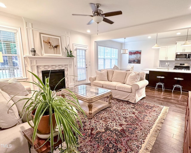 409 Eagle Ct, Henderson, NC 27536 - living room featuring ornamental molding, wood finished floors, ceiling fan, recessed lighting, and a tile fireplace