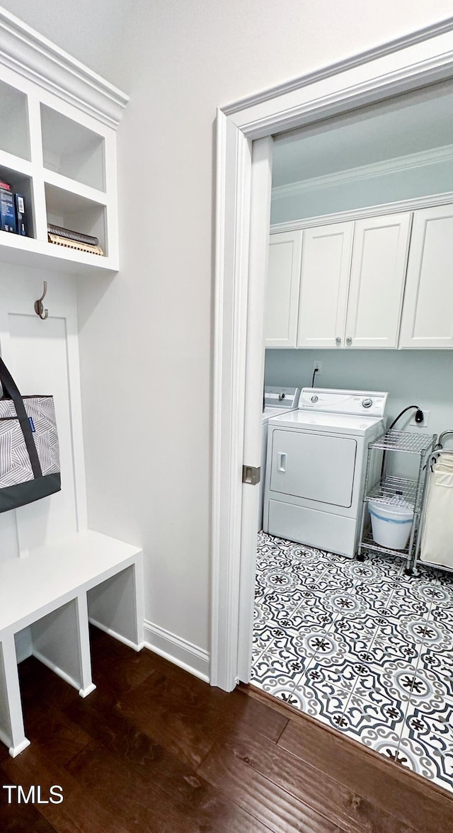 409 Eagle Ct, Henderson, NC 27536 - clothes washing area featuring baseboards, cabinet space, dark wood-style floors, and washing machine and clothes dryer
