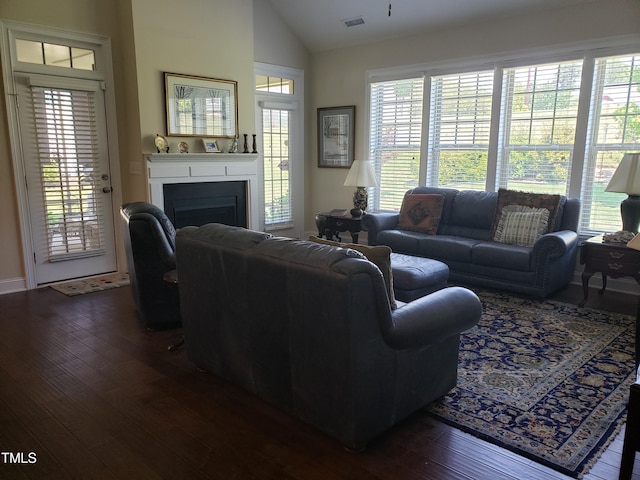 living room featuring visible vents, lofted ceiling, a fireplace, baseboards, and dark wood-type flooring