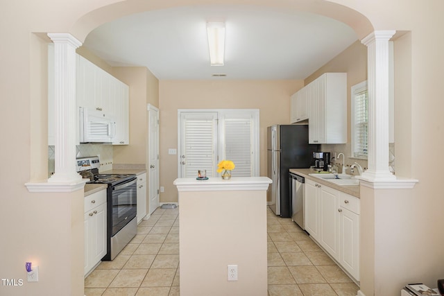 209 Mccarthy Dr, Clayton, NC 27527 - kitchen featuring stainless steel appliances, a center island, arched walkways, and ornate columns