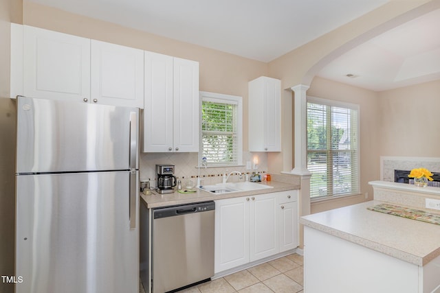 209 Mccarthy Dr, Clayton, NC 27527 - kitchen featuring stainless steel appliances, a sink, tasteful backsplash, arched walkways, and light countertops