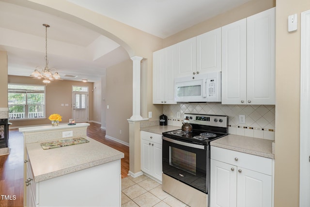 209 Mccarthy Dr, Clayton, NC 27527 - kitchen featuring electric range, white microwave, decorative columns, arched walkways, and tasteful backsplash