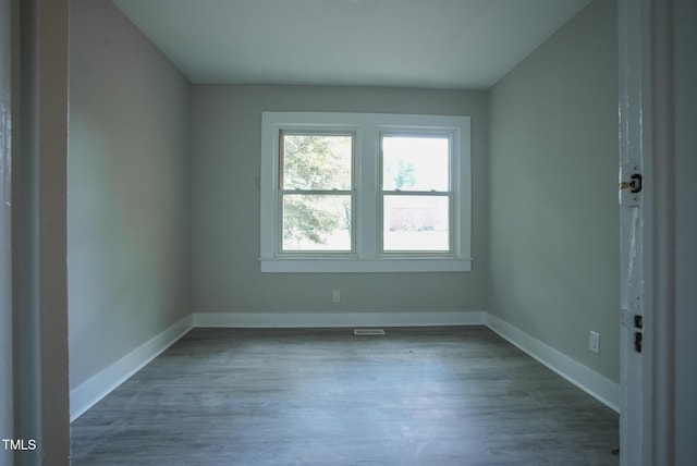 spare room featuring wood finished floors and baseboards
