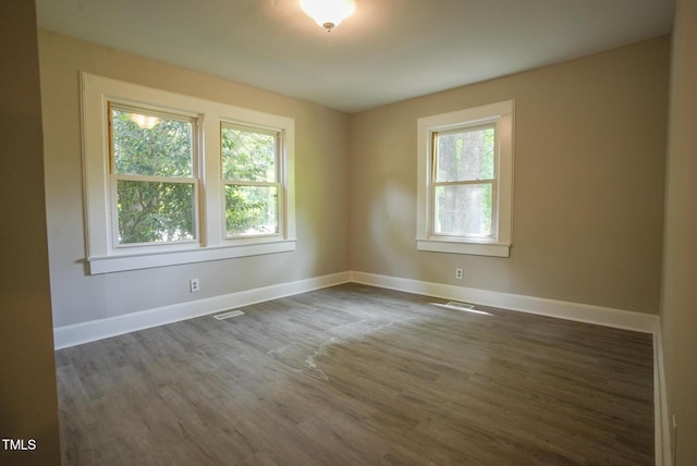 unfurnished room with dark wood finished floors and baseboards