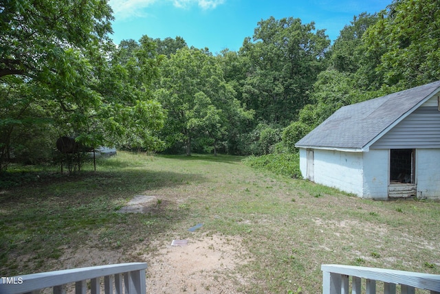 view of green lawn with a forest view