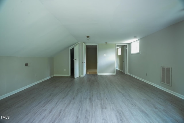 bonus room with wood finished floors, baseboards, and lofted ceiling