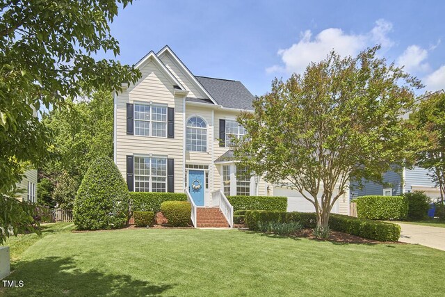 view of front facade with a front yard and concrete driveway