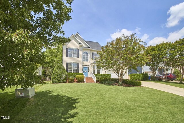 view of front of property with concrete driveway and a front yard