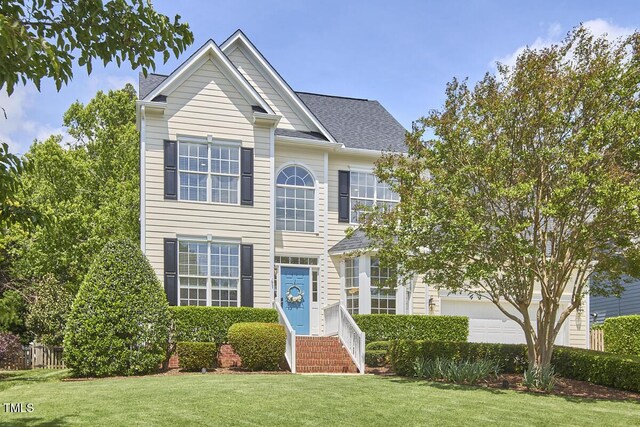 view of front of property with a front yard and a garage