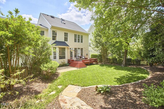 back of property featuring a yard, a deck, and a fenced backyard