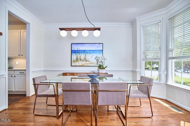 dining space featuring crown molding, visible vents, and wood finished floors