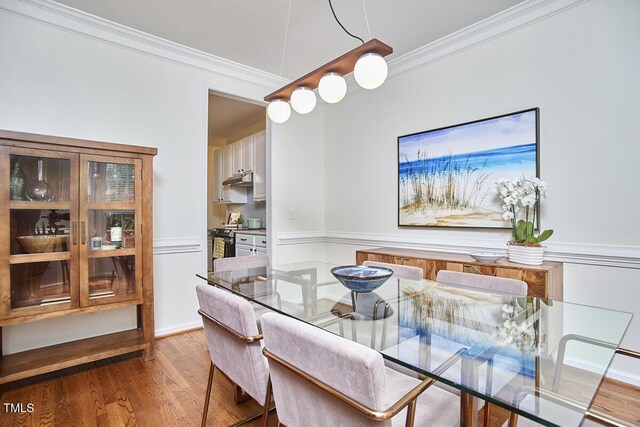 dining area featuring ornamental molding and wood finished floors