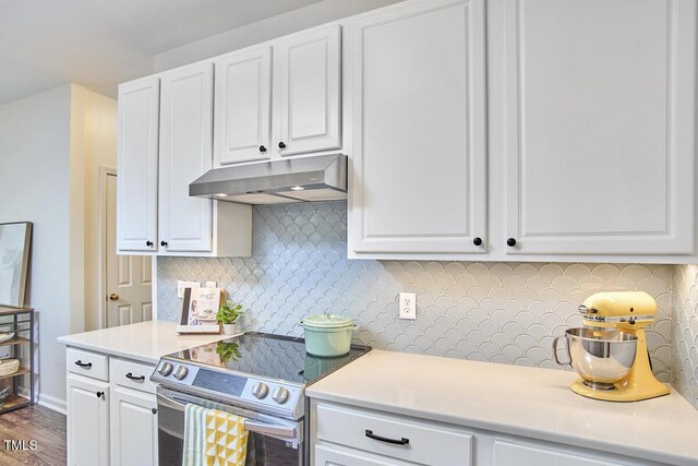 kitchen featuring stainless steel electric range oven, backsplash, under cabinet range hood, and white cabinetry