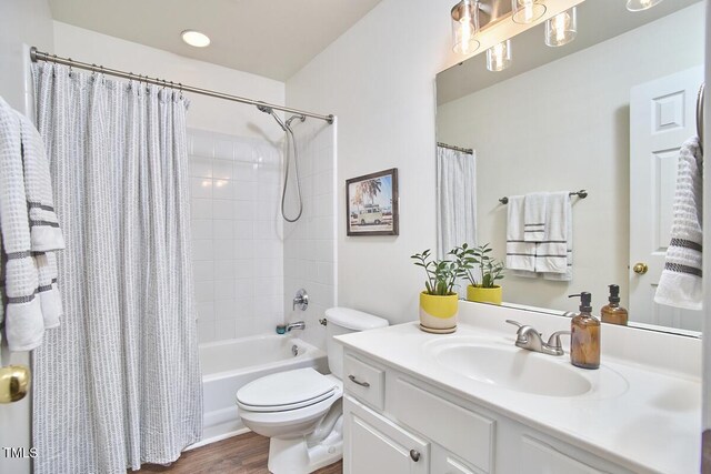 full bath featuring toilet, wood finished floors, shower / tub combo, and vanity