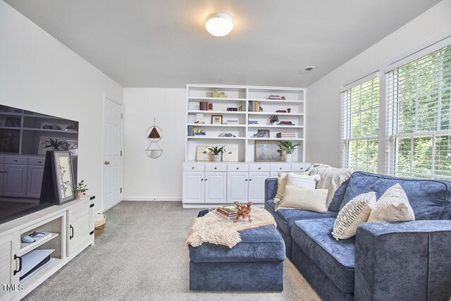 living room featuring light colored carpet, baseboards, and visible vents