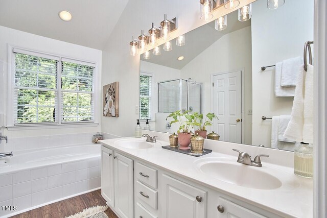 full bathroom featuring vaulted ceiling, a sink, a bath, and a stall shower