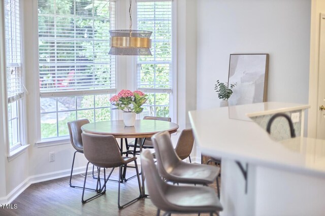 dining area with baseboards and dark wood-style flooring