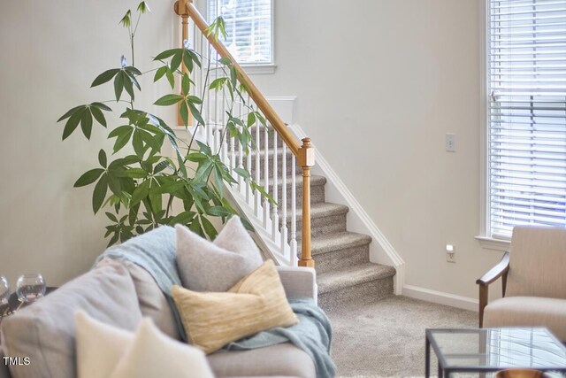 living room featuring baseboards, carpet flooring, and stairs