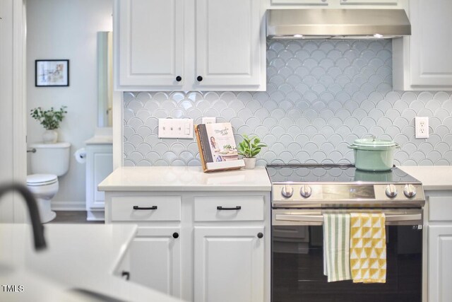 kitchen featuring backsplash, stainless steel electric range, white cabinetry, light countertops, and extractor fan