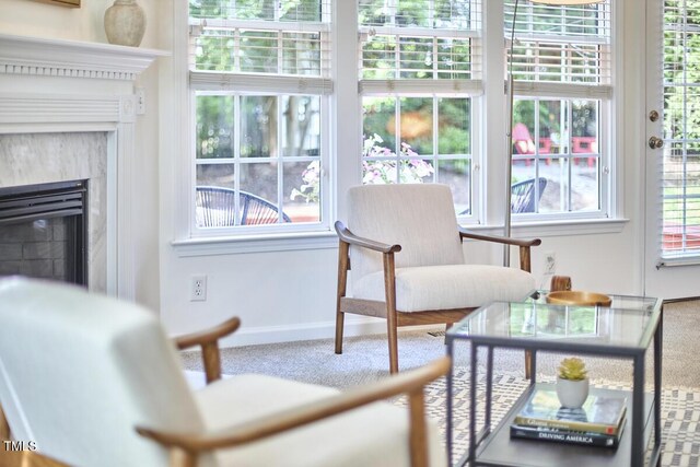 interior space with carpet floors, baseboards, and a glass covered fireplace
