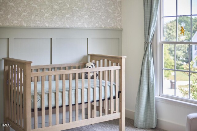 bedroom featuring a crib and carpet