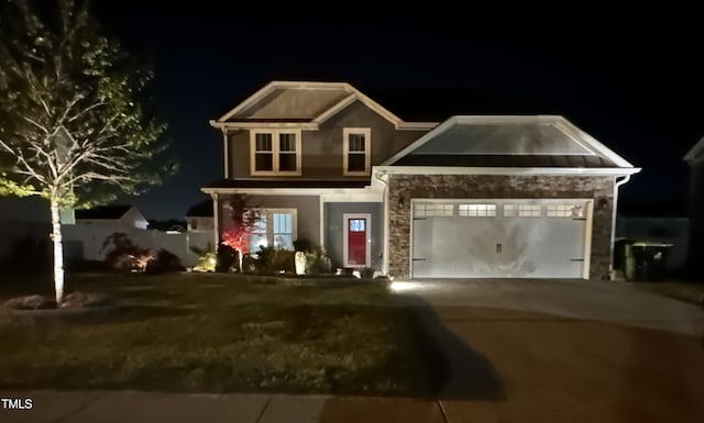 view of front of property featuring an attached garage, concrete driveway, and stone siding