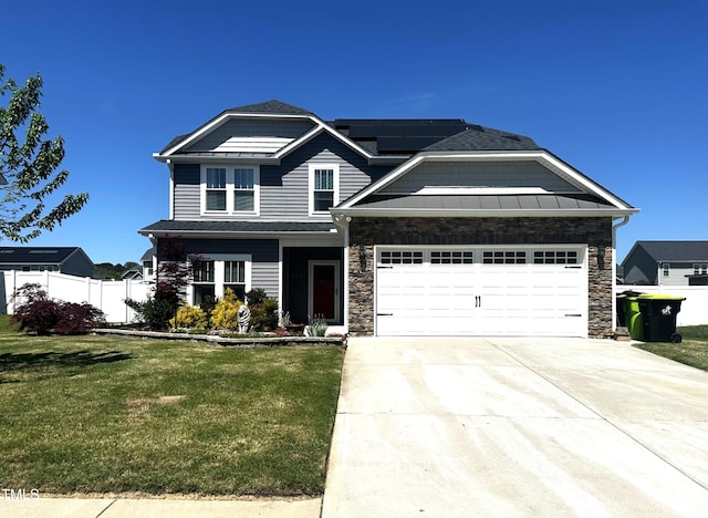 view of front of property with driveway, solar panels, a garage, fence, and a front lawn