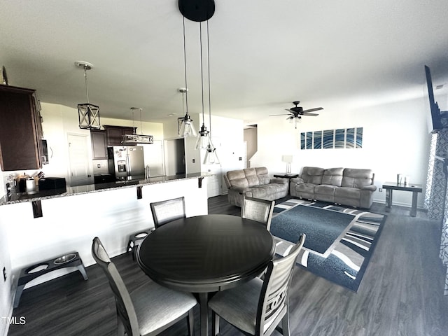 dining area with ceiling fan and dark wood-style floors