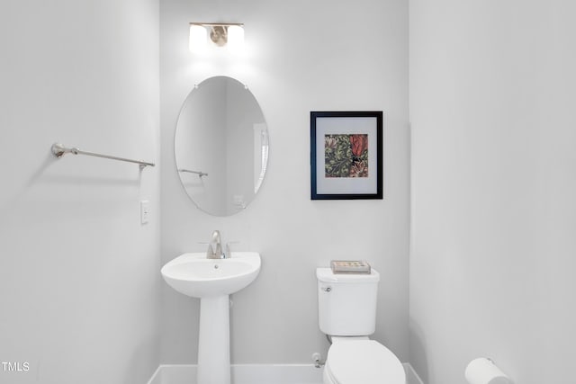 bathroom with baseboards and toilet