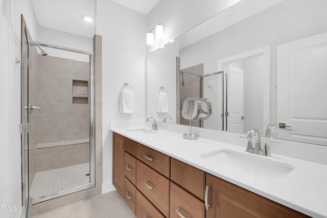 full bath featuring a sink, tile patterned flooring, a shower stall, and double vanity