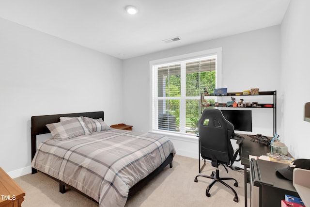 bedroom with baseboards, light colored carpet, and visible vents