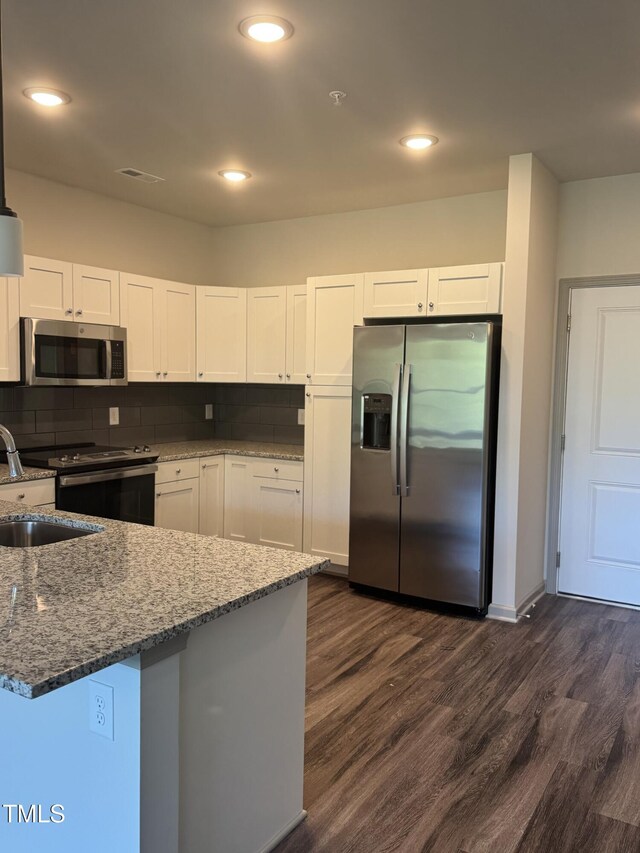 2418 Gathering Square Ct, Fuquay Varina, NC 27526 - kitchen with dark wood finished floors, stone countertops, appliances with stainless steel finishes, and white cabinetry