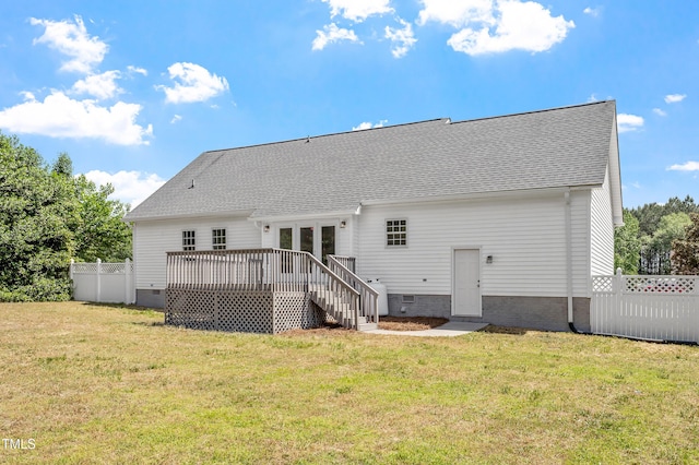 back of property featuring fence, a yard, crawl space, and a deck