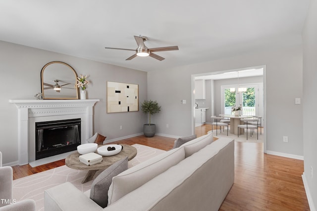 5612 Sandy Trail Dr, Knightdale, NC 27545 - living area with ceiling fan, baseboards, a fireplace with flush hearth, and light wood-style floors
