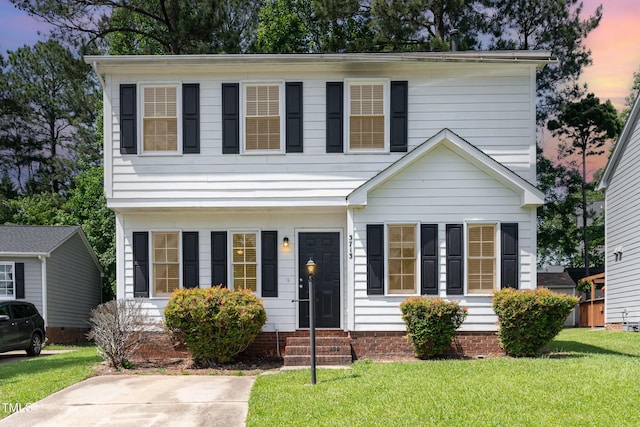 colonial inspired home featuring entry steps and a yard