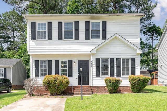 colonial inspired home featuring entry steps and a front yard