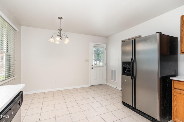 kitchen with stainless steel appliances, light countertops, a chandelier, pendant lighting, and baseboards