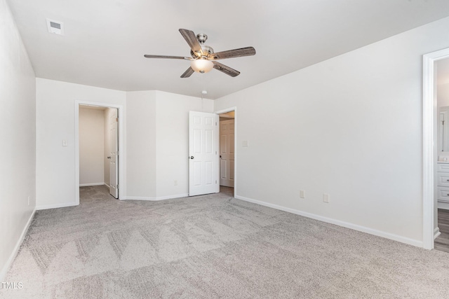 unfurnished bedroom with carpet flooring, baseboards, ensuite bathroom, and a ceiling fan