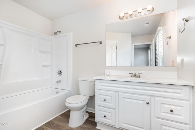 full bath with toilet, wood finished floors, vanity, and shower / bathtub combination