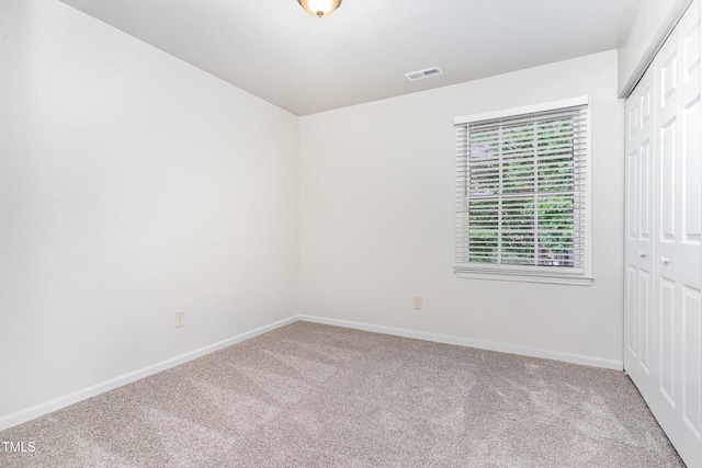 carpeted empty room featuring baseboards